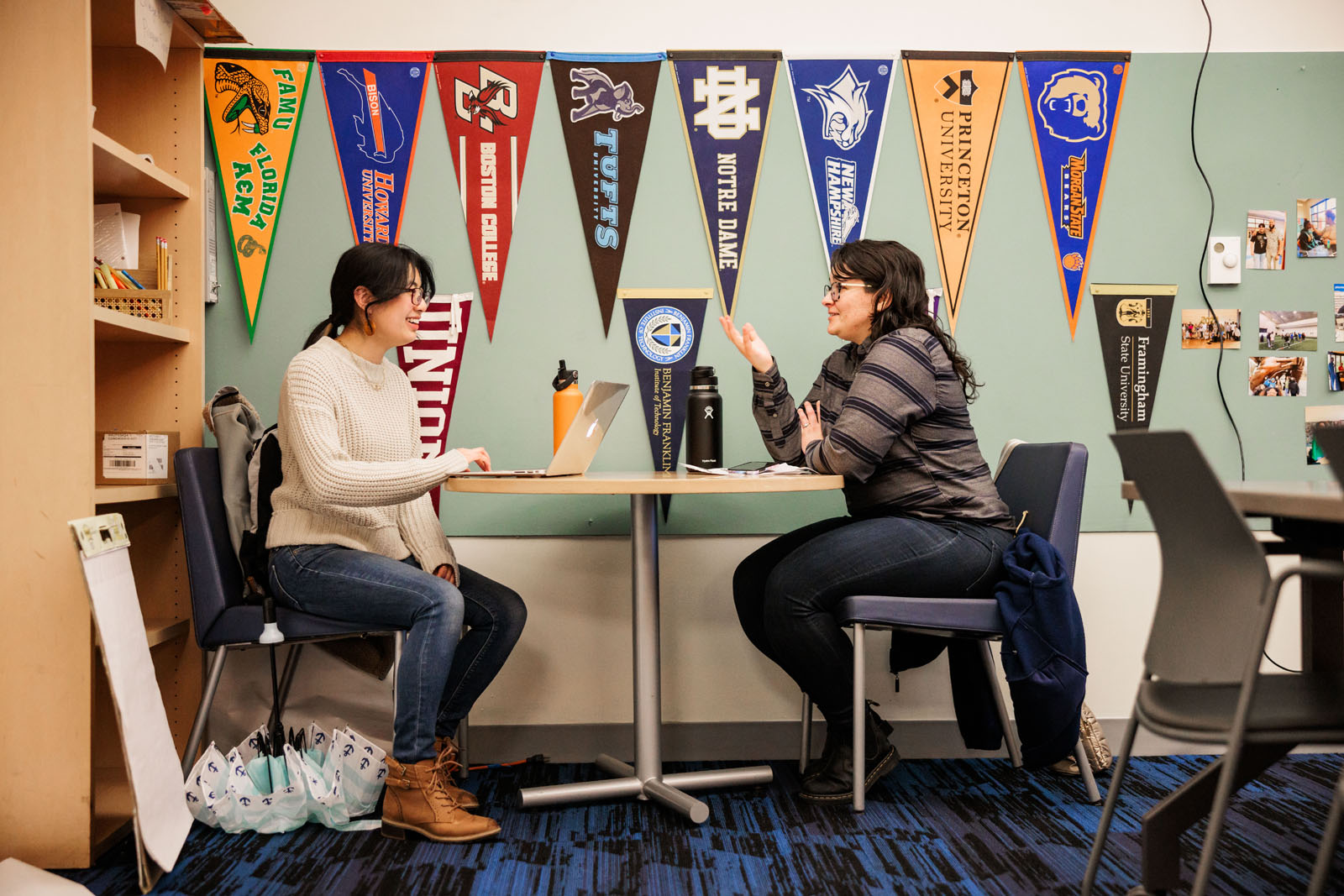 A teen and staff member meeting to discuss in the College and Career Center.